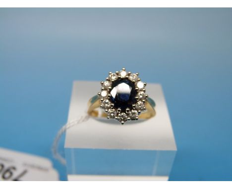 An 18ct gold ring set with an oval cut sapphire surrounded by diamonds (size L)