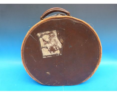 A vintage circular leather mounted hat box with lined interior and pocket to lid