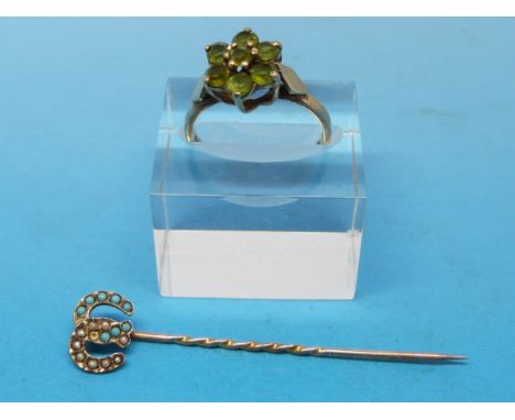 A 9ct gold ring set with peridots in a flower cluster and a yellow metal stick pin set with turquoise and seed pearl marked 9