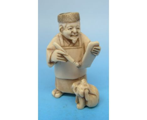 A Japanese ivory netsuke in the form of a scholar with a dog by his left foot