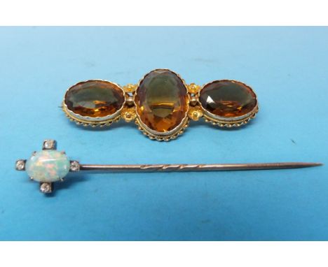 A yellow metal brooch marked 12ct set with three oval cut citrines and a stick pin set with an oval opal and diamonds 