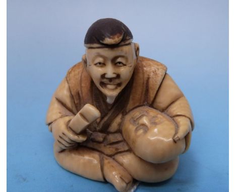 A Japanese ivory netsuke of a mask maker