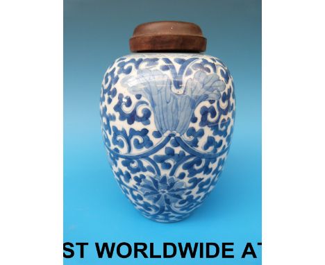 An 18thC Chinese blue and white jar with scrolling floral decoration and fitted wooden top (19.5cm tall) 