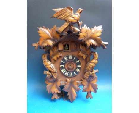 A large Black Forest cuckoo clock with seated man and cuckoo feature 