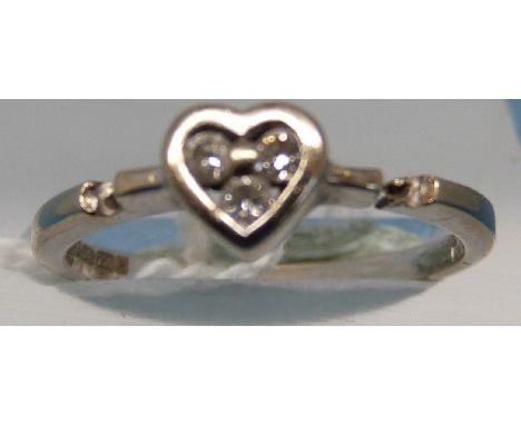 An 18ct white gold ring set with three diamonds in a heart setting (size K)