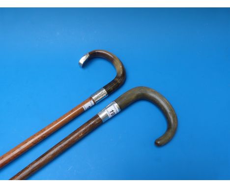 A rhinoceros handled walking stick with a silver collar (Birmingham 1931) and a buffalo handled walking stick with a silver c