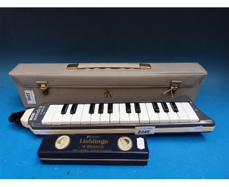 A two octave cased Hohner melodica together with a Lieblinge Hohner 24 holed tremelo harmonica in C