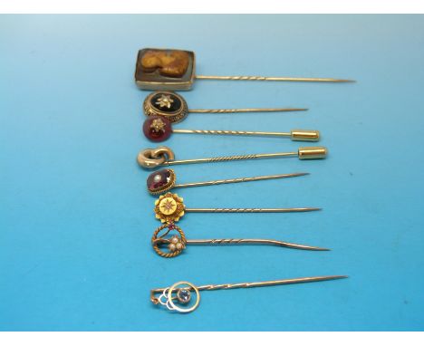 Eight stick pins to include a 15ct example set with a diamond, 9ct gold set with a sapphire etc 