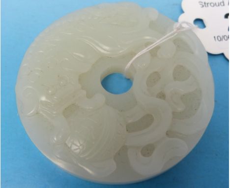 A Chinese white jade bi disk with relief carving of a Buddhistic lion playing with a brocade ball (diameter 5.4cm)