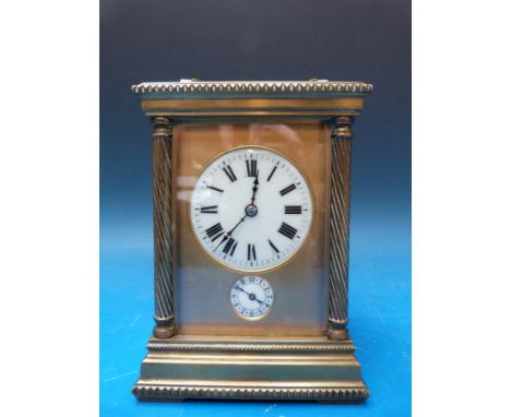 A late 19th/ early 20th century brass carriage clock with strike and alarm mechanism, the ivory coloured dials set in gilt su