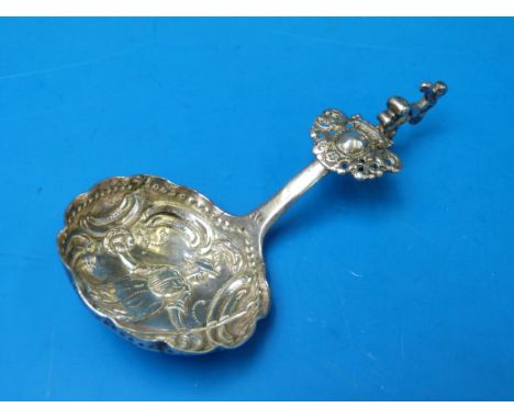A late 19thC continental white metal figural caddy spoon with repoussé decoration to the bowl, length 11cm