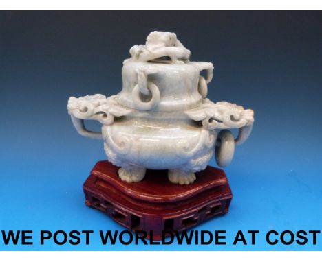 A Chinese pale greyish-green jadeite tripod censer carved with dragon head ring handles and coiled dragon finial, on fitted w
