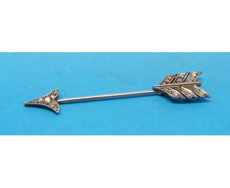 A platinum and gold pin set with diamonds in the shape of an arrow 