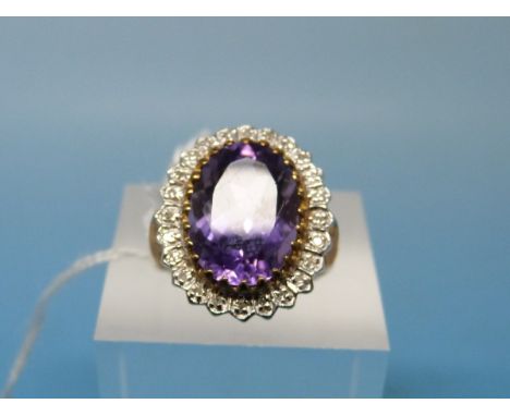 A 9ct gold ring set with a large amethyst surrounded by diamonds (size K)