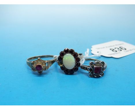 Two 9ct and silver rings, one set with an opal surrounded by red stones, the other set with a red stone together with another