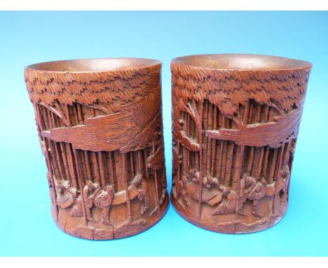 A pair of Chinese bamboo brush pots carved with scenes of scholars reading and playing chess, 14cm tall