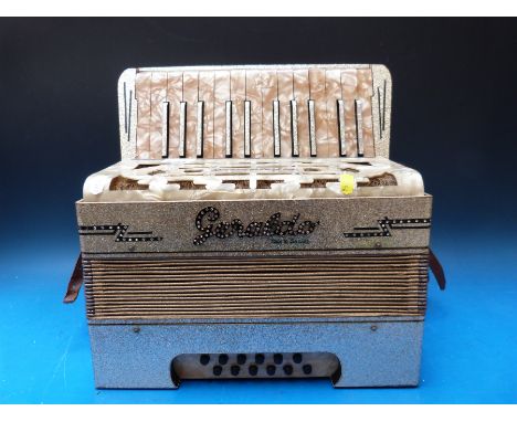 A Geraldo German 12 bass piano accordion, in sparkly gold finish with peach coloured piano keys (with case)