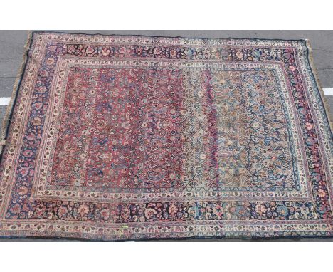 A large vintage woollen rug with multiple borders and red and blue ground (L373 x W251cm)