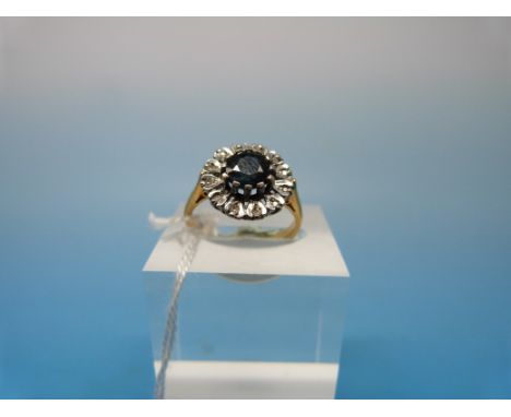 An 18ct gold ring set with a central sapphire surrounded by diamonds in a flower cluster (size L)