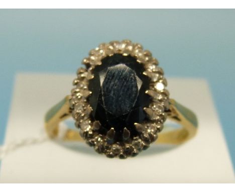 An 18ct ring set with a central sapphire surrounded by diamonds (size K) 