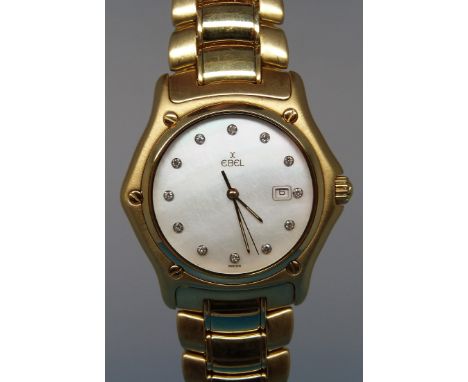 An 18ct gold Ebel 1911 wristwatch with clear stone hour markers and date aperture on mother of pearl face. 