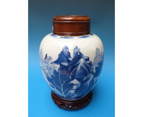 A Chinese blue and white jar with landscape scene with fitted wooden top and stand, possibly Kangxi (28cm tall on stand) 