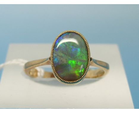 A yellow metal ring set with an oval fire opal (size L) 