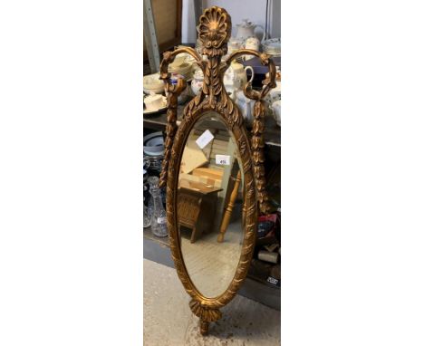 GILT FRAMED OVAL MIRROR WITH DECORATIVE CARVINGS