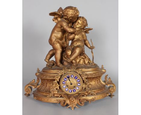 A 19TH CENTURY FRENCH GILDED CAST METAL MANTLE CLOCK, with eight-day movement, blue and white enamelled numerals, the case su