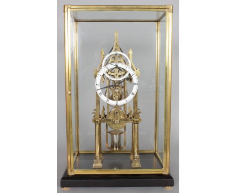A BRASS SKELETON CLOCK, 20TH CENTURY, with circular enamel dial and subsidiary seconds dial, housed in a glass case. Clock 1f