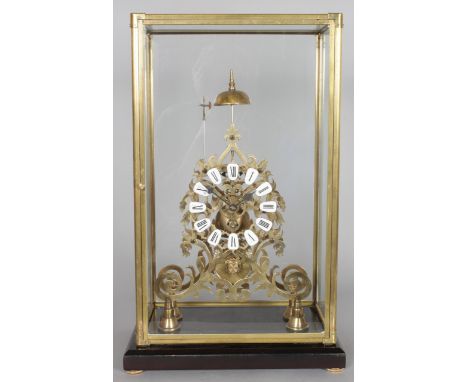A BRASS SKELETON CLOCK, 20TH CENTURY, with enamel numerals, housed in a glazed case. Clock 1ft 5ins high.