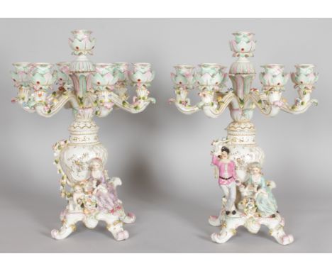 A PAIR OF DRESDEN STYLE PORCELAIN SEVEN LIGHT CANDELABRA with six scrolling branches, gallant and young lady to the base. 1ft