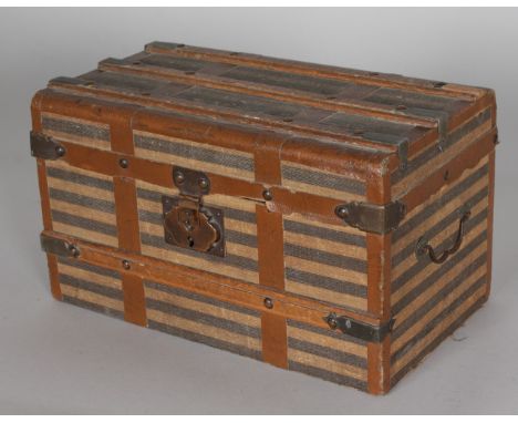 A MINIATURE TRAVELLING TRUNK, brass bound with wood and leather strapwork. 11ins long x 6.5ins deep x 6.5ins high.