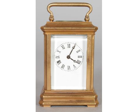 A MINIATURE BRASS CARRIAGE CLOCK, with white enamel dial. 3ins high.