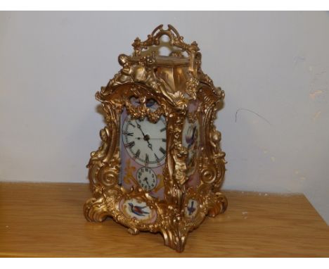 A reproduction gilt metal  repeating mantel/carriage clock with painted porcelain panels.