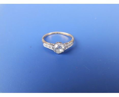 A diamond solitaire, the claw set brilliant weighing approximately 0.50 carat with small diamonds to shoulders on 18ct yellow