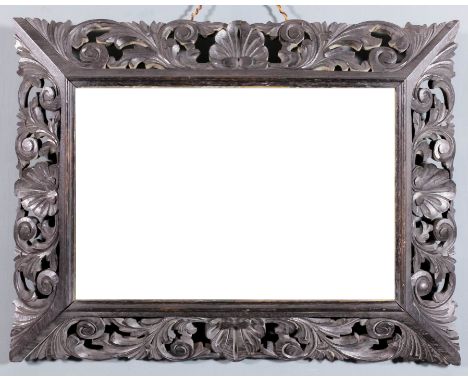 A late 19th Century carved oak framed rectangular wall mirror with bold leaf scroll carved frame and inset with bevelled mirr
