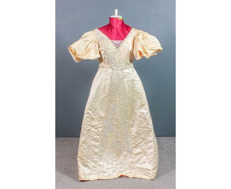 An 1850s oyster satin beaded wedding dress, the bodice and central panel worked with floral ornament, with fishtail train, si