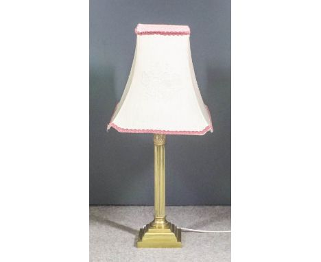A brass electric table lamp of Corinthian column form, on square stepped base, 20ins high, and shade for same