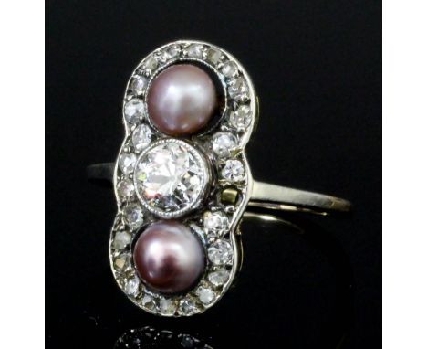 A late Victorian gold and silvery metal mounted pearl and diamond ring, the central old cut stone of approximately .25ct shou