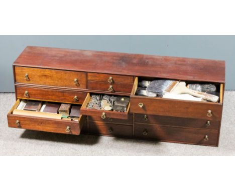 A mahogany nest of fourteen small drawers, 39ins wide x 9.25ins deep x 13.5ins high, containing a selection of various tools 