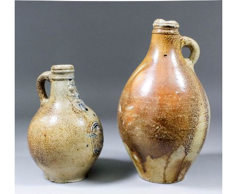 A 17th Century German salt-glazed stoneware Bartmannskrug (Bellarmine), with moulded bearded mask to neck and oval panel to b