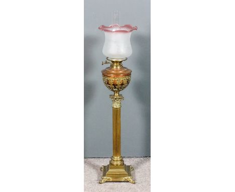 A late 19th Century brass oil lamp, the Corinthian column with acanthus capital, on a stepped base supporting a pierced brass