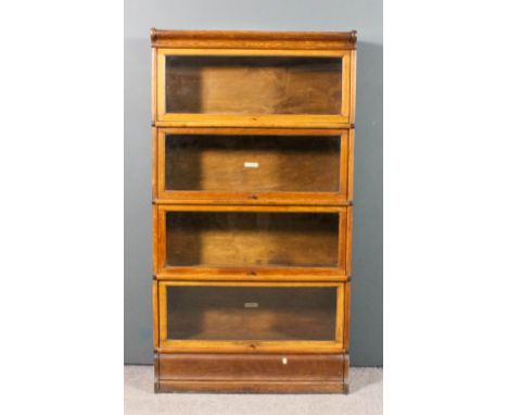 A pair of 1920s Globe Wernicke oak four tier sectional bookcases with glazed rising fronts, 34ins wide x 10ins deep x 64ins h