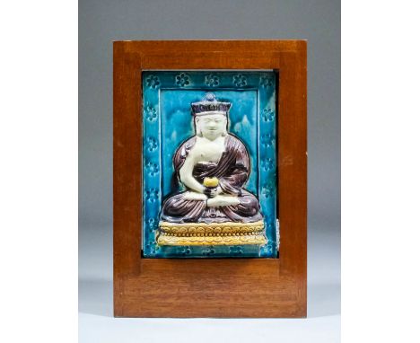 A Chinese Fahua tile panel, relief moulded with a seated Bodhisattva within a turquoise border, 9.5ins (24cm) x 7ins (17.8cm)