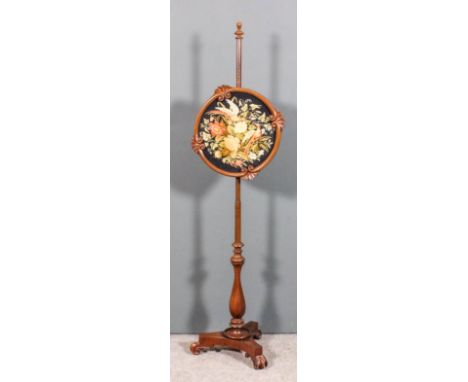 A Victorian mahogany pole screen the circular panel with scroll and fan carved frame and inset with needlework panel of birds
