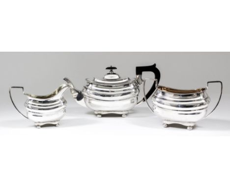 An Edward VII silver rectangular three piece tea service with gadroon mounts, moulded bodies, angular loop handles and on bun