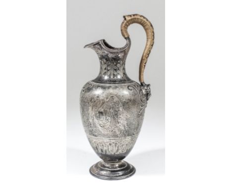 A Victorian silver urn pattern water jug with shaped and moulded rim, cane covered handle with mask terminal, the body engrav