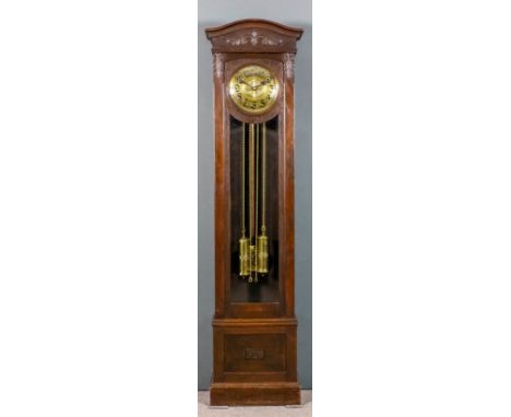 An early 20th Century Continental dark oak longcase clock, the 10.5ins diameter embossed brass dial with Arabic numerals to t
