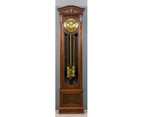 An early 20th Century Continental dark oak longcase clock, the 10.5ins diameter embossed brass dial with Arabic numerals to t